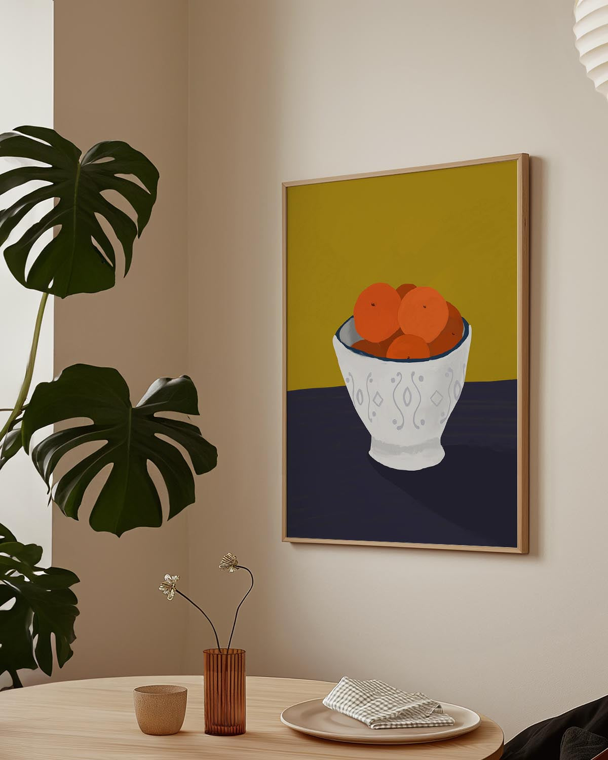 Minimalist still life poster of a patterned white bowl filled with oranges on a mustard yellow and dark navy background.