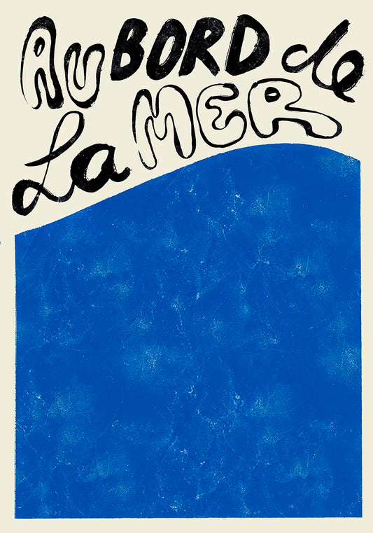 Artistic poster with the French phrase 'Au bord de la mer' in bold black script at the top, over a textured deep blue background that fills the lower section, evoking the peacefulness of the ocean."