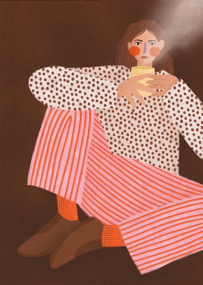 Woman holding a yellow coffee cup poster, wearing pink striped trousers and a polka-dot blouse against a brown background.