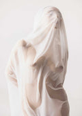 An artistic, minimalist photograph titled Ethereal_White_Form_by_Enis_Onur, featuring a human figure enveloped in a translucent, wet white fabric that clings to the skin like a sculptural veil. The monochromatic, bright white aesthetic highlights fluid silhouettes, soft shadows, and abstract body contours against a clean, bright background.