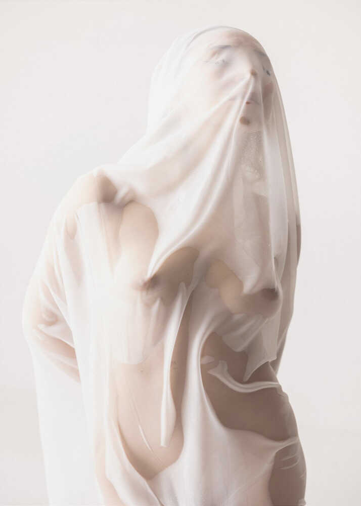 An artistic, minimalist photograph titled Ethereal_White_Form_by_Enis_Onur, featuring a human figure enveloped in a translucent, wet white fabric that clings to the skin like a sculptural veil. The monochromatic, bright white aesthetic highlights fluid silhouettes, soft shadows, and abstract body contours against a clean, bright background.
