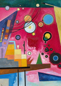 Abstract painting titled Heavy Red by Wassily Kandinsky, featuring a vibrant magenta and deep red background filled with geometric shapes. Floating circles resembling planets are connected by curved black lines, alongside a stepped, multicolored architectural structure on the left, a green triangle, and varying blue and yellow geometric forms.