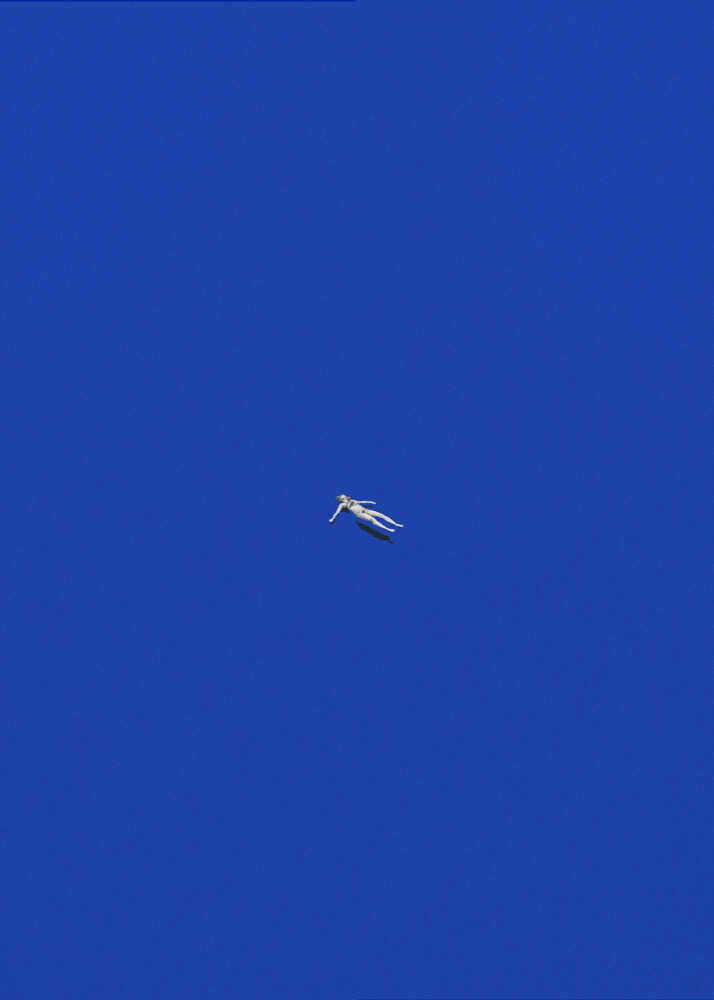 A minimalist art print titled "No Stress" featuring a tiny figure of a woman floating peacefully in the center of a vast, solid deep blue background. The composition is clean and modern, emphasizing solitude and tranquility.