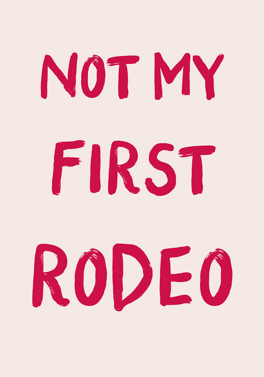 パステルピンクの背景に赤の太い筆文字フォントで「NOT MY FIRST RODEO」と書かれた、ユーモアと自信を感じさせるトレンディなポスター。