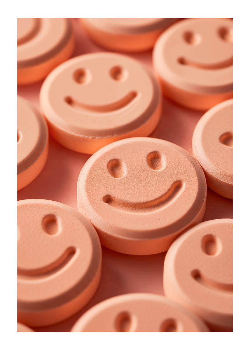 Close-up poster of peach-colored pills with smiley faces, creatively arranged to evoke a sense of happiness and positivity against a soft, matching background.