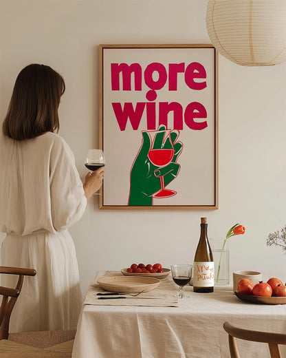 Bold magenta 'More Wine' text with playful hand holding a glass illustration on a white backdrop.