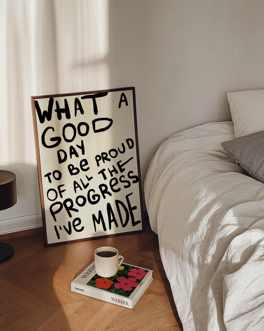 Hand-drawn typography poster with bold black brushstroke text reading, "What a good day to be proud of all the progress I’ve made," on a light background. Motivational and expressive design.