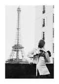 Black and white photograph of a woman in a white jacket and skirt in front of the Eiffel Tower, Paris