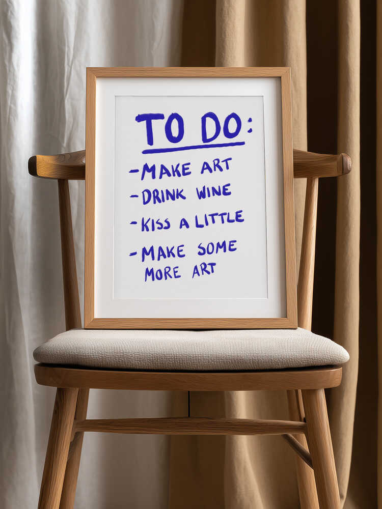 Handwritten poster with a playful to-do list in bold purple text: "Make art, drink wine, kiss a little, make some more art" on a white background.